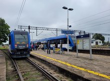 Pociąg pasażerski stojący przy peronie stacji Ełk oraz podróżni stojący na peronie fot. Mirosław Siemieniec