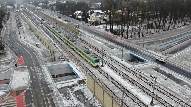 Skrzyżowanie bezkolizyjne w Kobyłce, widać pociąg, jezdnię i ścieżkę rowerową w tunelu pod torami, fot. A.Lewandowski, P.Mieszkowski