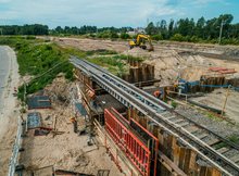 Widok z powietrza na budowę nowego przystanku kolejowego Białystok Zielone Wzgórza. Widać pracujących robotników i koparkę.
