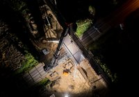 Nocny widok z powietrza na montaż metalowej konstrukcji wiaduktu kolejowo-drogowego nad drogą krajową nr 63 w Czyżewie. 