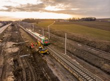 Szlak Szepietowo-Łapy, pociąg jedzie obok pracujących maszyn.