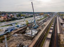 Widok z powietrza na stację kolejową w Szepietowie. Widać maszyny budowlane i pociągi towarowe.