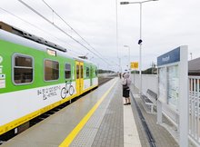 Zdjęcie przedstawia nowy peron na stacji kolejowej Prostyń. Widoczny jest również pociąg osobowy i oczekujących pasażerów.