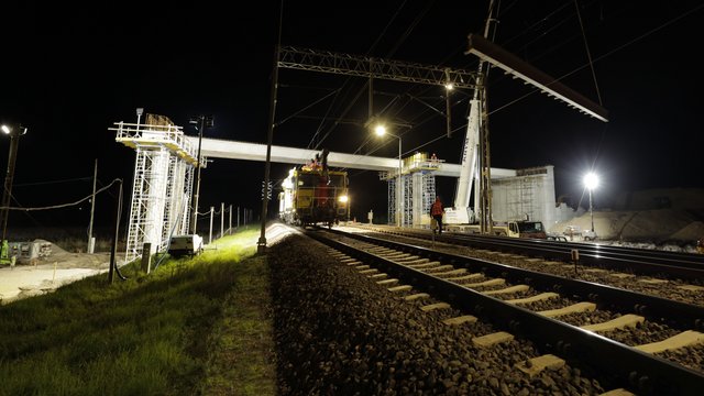 Budowa wiaduktu w Małkini, dźwig układa zbrojone belki, jedzie drezyna, autor Łukasz Bryłowski