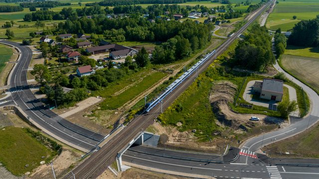 Widok z lotu ptaka. Wiadukt w Szepietowie, pociąg pasażerski jedzie po torach fot. Łukasz Bryłowski